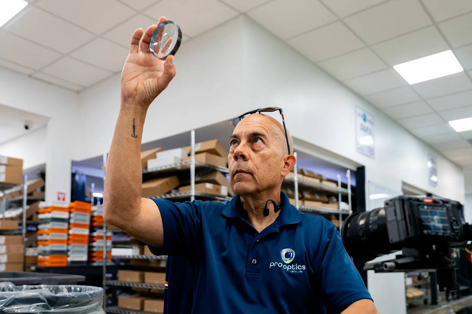 Técnico de PR Optics inspeccionando un lente a contraluz en Caguas