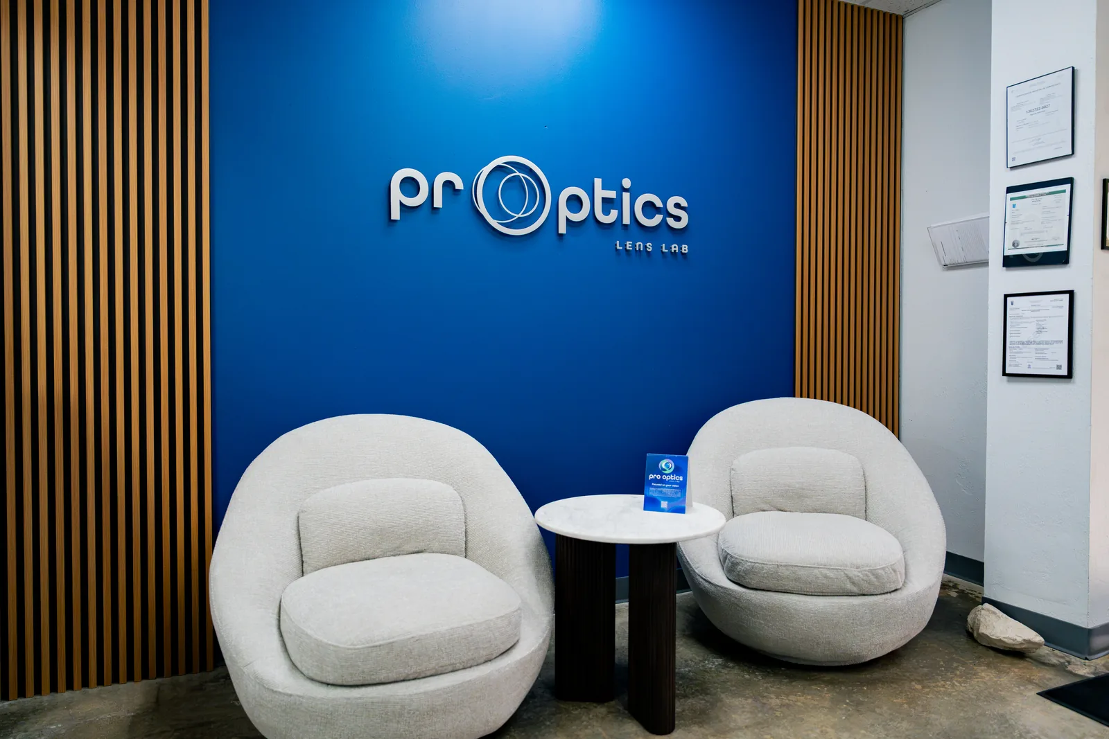 Sala de espera del laboratorio PR Optics con el rótulo de la marca