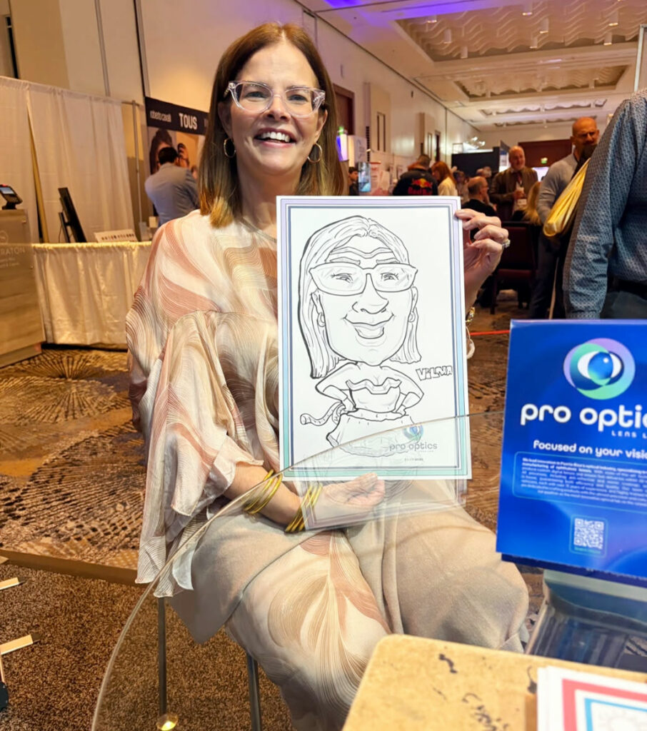 Visitante muestra su caricatura en el booth de PR Optics